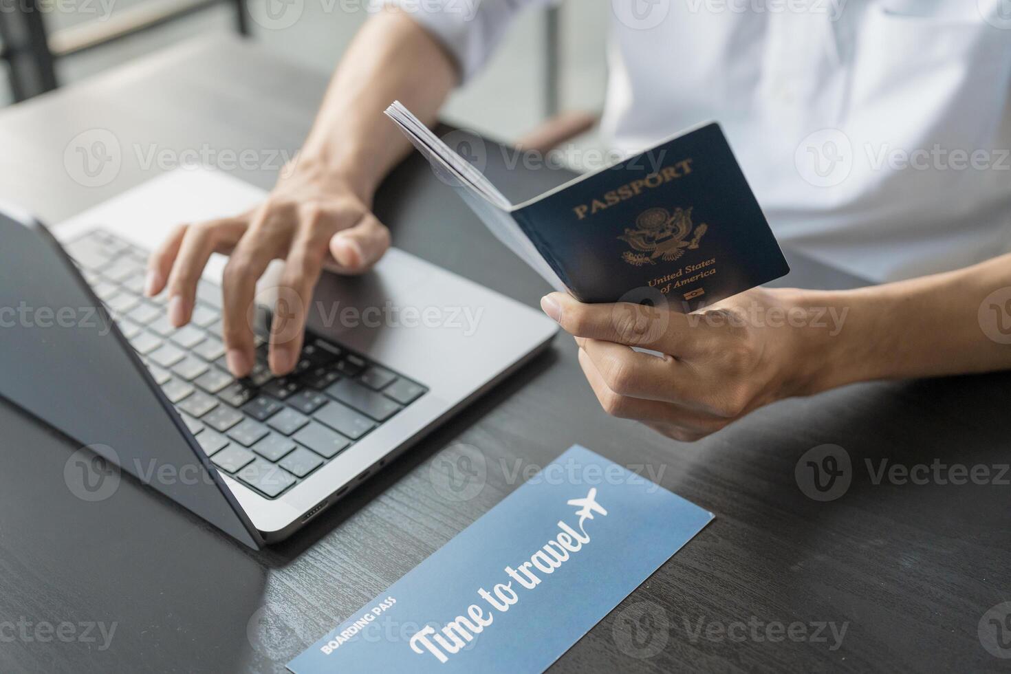Hand Man Online booking and buying plane tickets using laptop phone and credit card Planning trip travel vacation with passport and ticket photo
