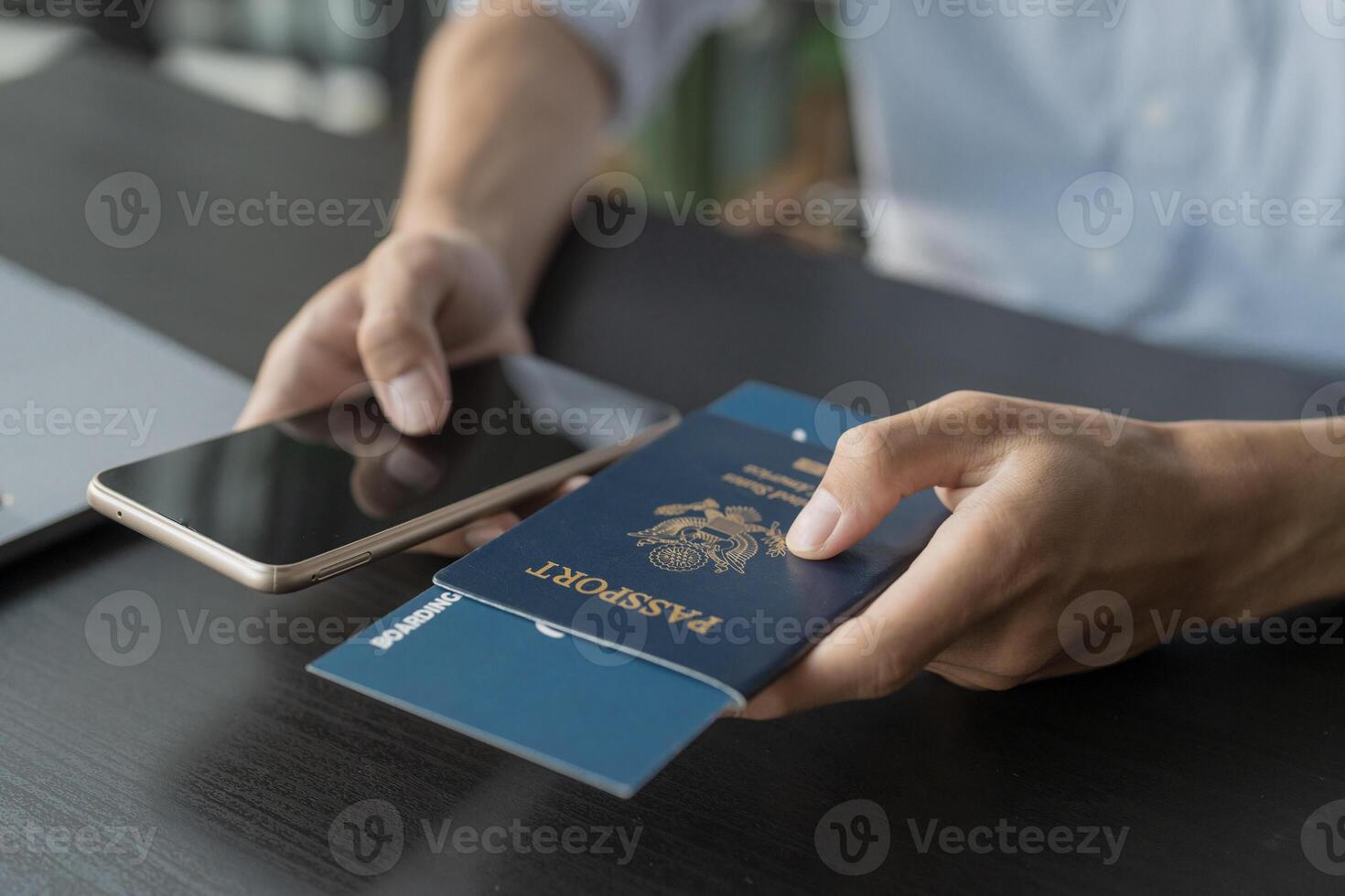 Hand Man Online booking and buying plane tickets using laptop phone and credit card Planning trip travel vacation with passport and ticket photo