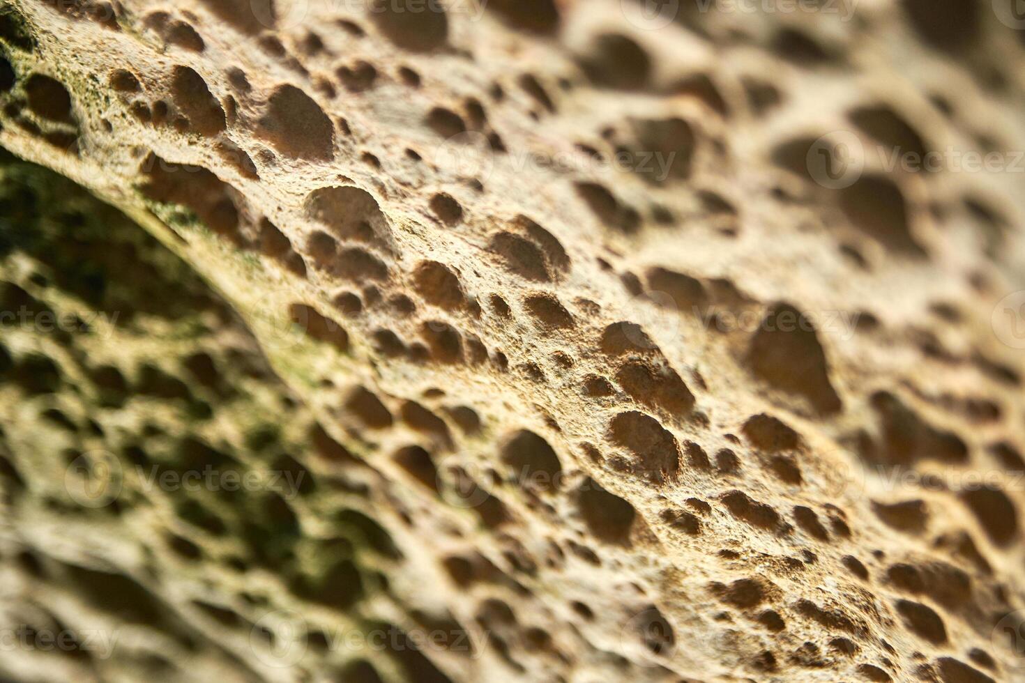 Close up of rugged rock surface with unique weathered textures and natural patterns. photo