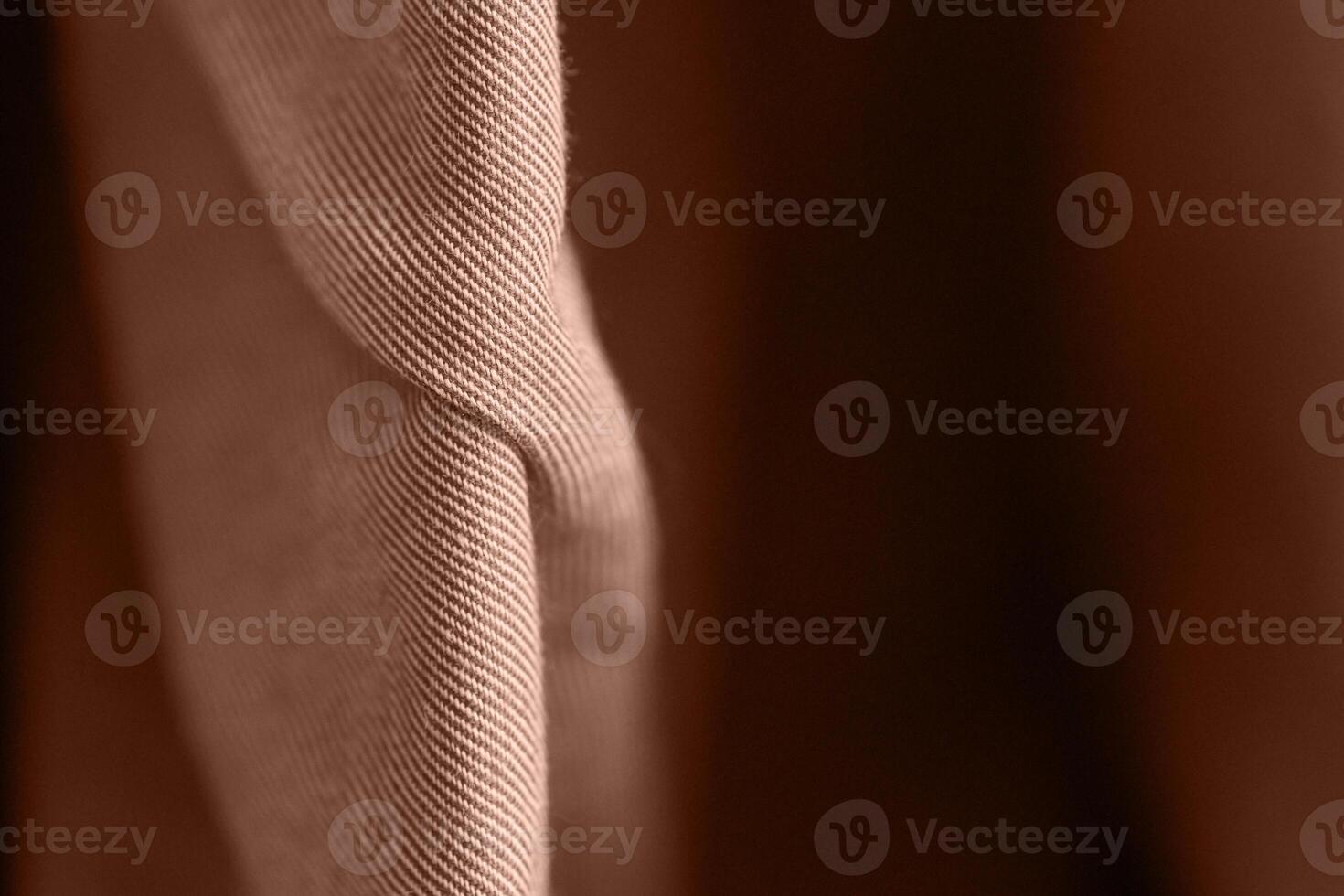 Close up of brown fabric with detailed texture and soft folds in subtle light. photo