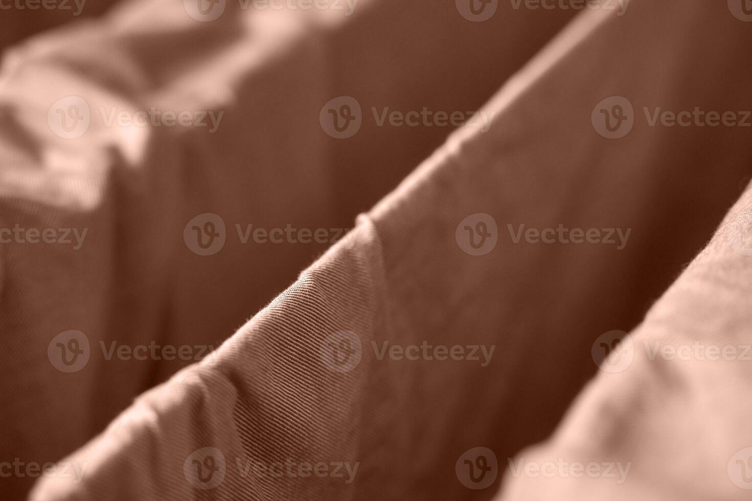 Close up view of brown fabric folds creating geometric patterns in soft light and gentle texture. photo