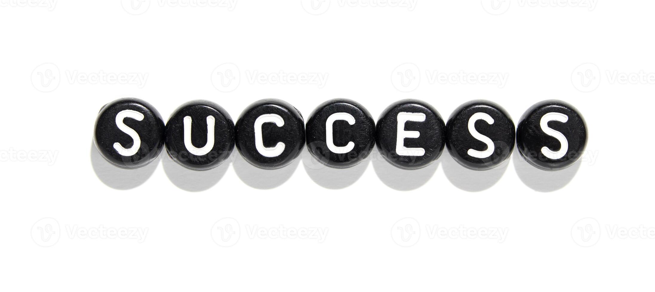 Minimalist alphabet beads arranged to spell success on white background for motivation and achievement concepts photo