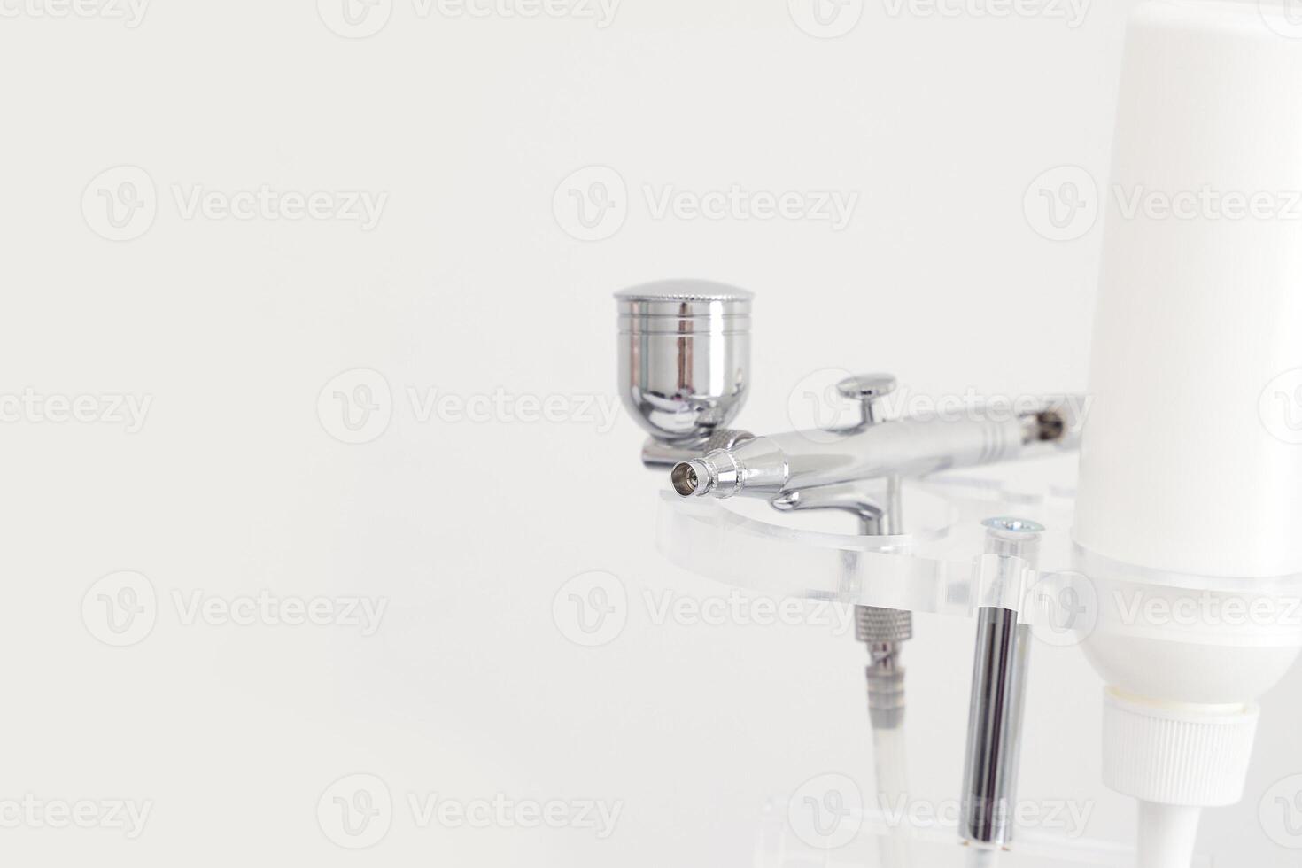 Close up of modern airbrush tool with white background for artistic painting techniques. photo
