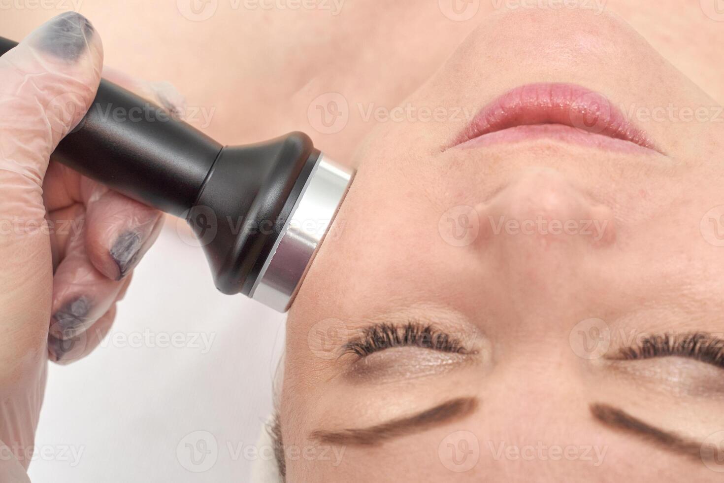 Caucasian female undergoing non invasive facial treatment for skin rejuvenation at spa, close up view. photo