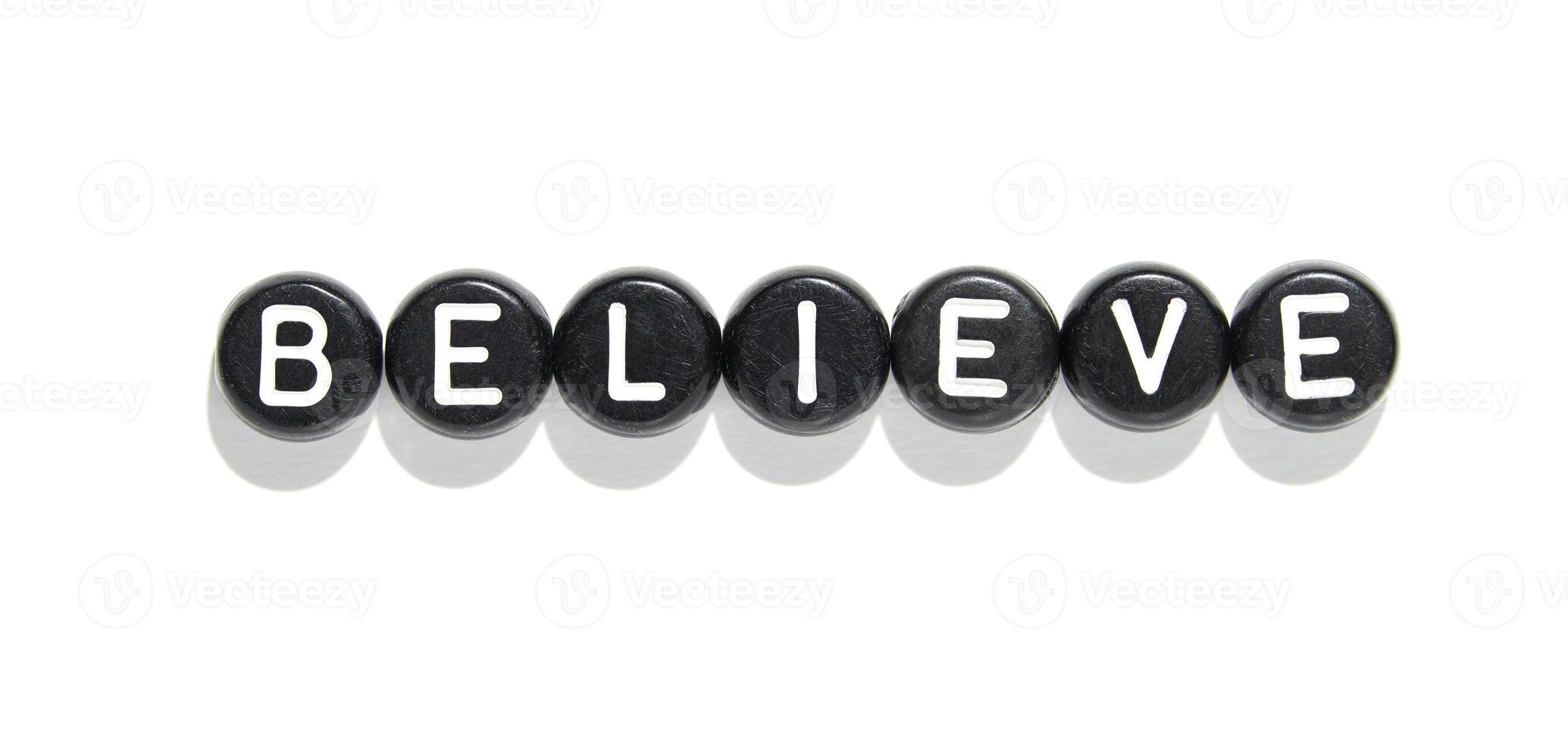 Believe conceptual word arrangement with black beads and white letters isolated on white background photo