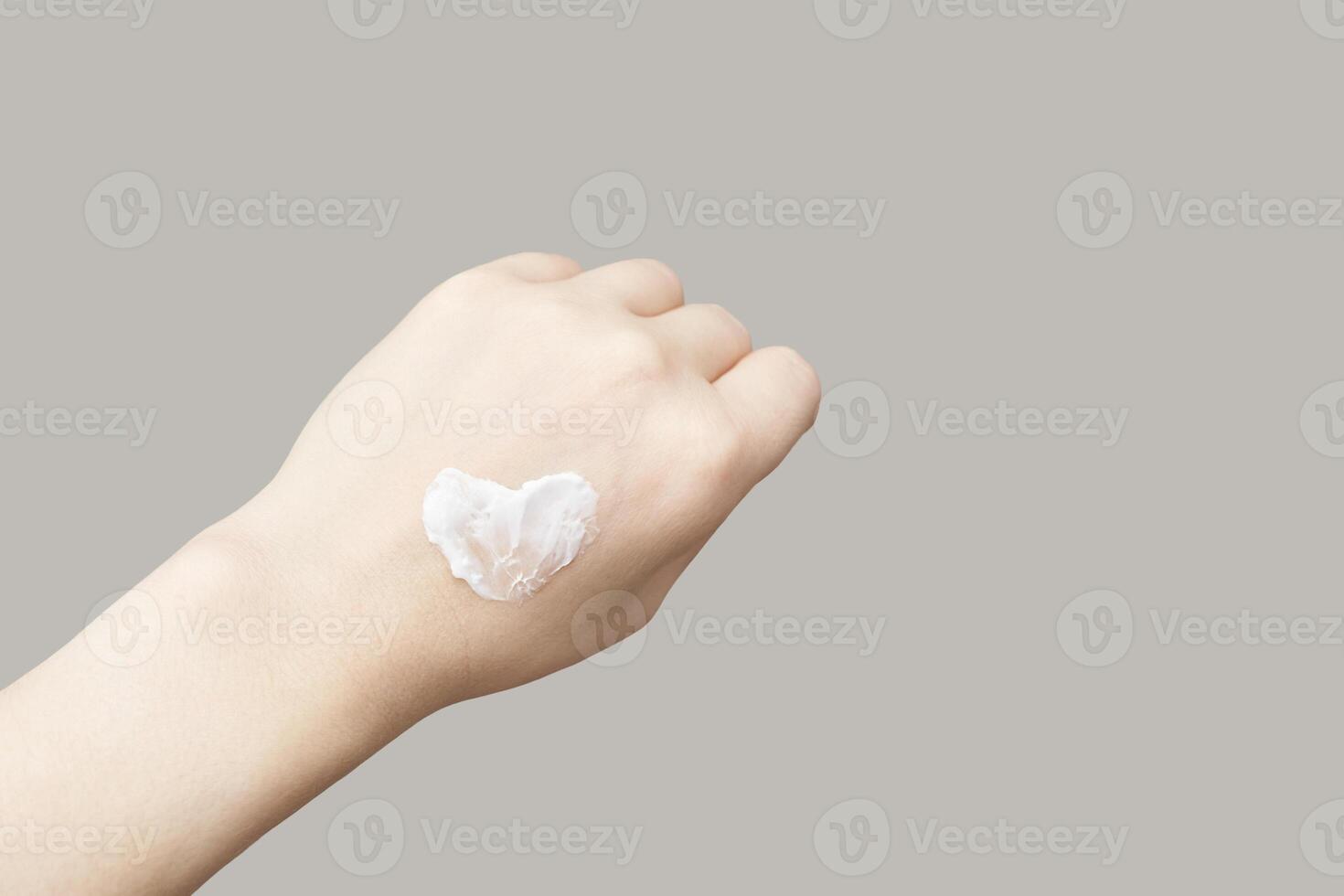 Caucasian female hand with heart shaped cream on neutral background for skincare concept. photo