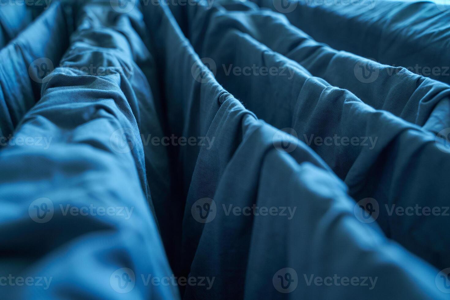 Close up of blue fabric folds with intricate textures and play of light and shadow. photo