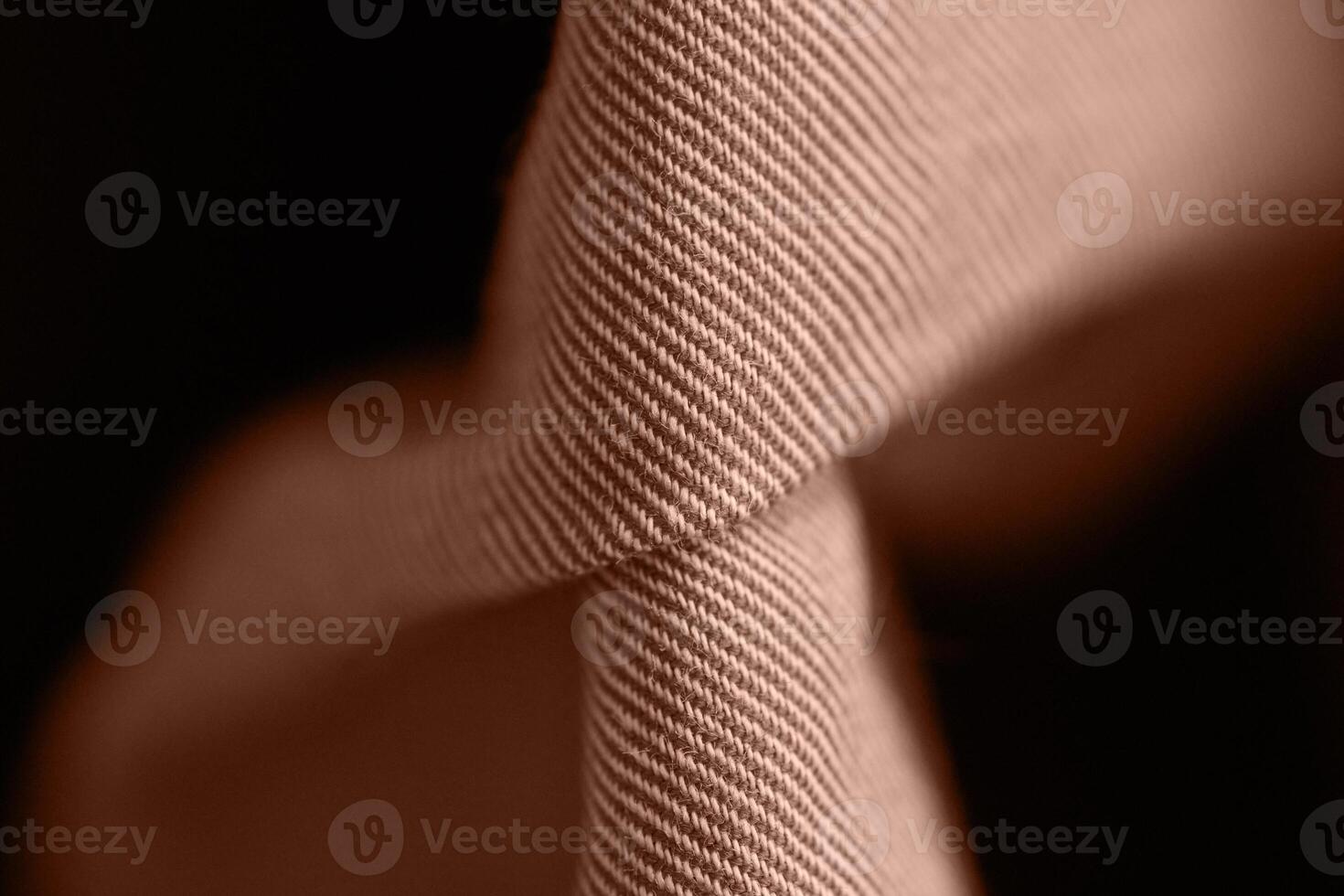 Close up of twisted brown fabric texture with detailed fibers in soft lighting. photo