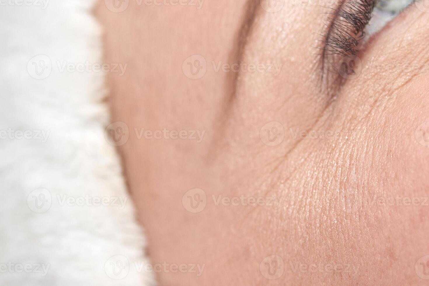 Close up of mature caucasian female skin showing wrinkles and texture highlighting natural aging process. photo