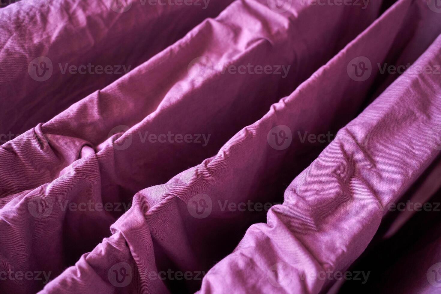 Vibrant purple fabric close up with wrinkled texture in indoor setting. photo