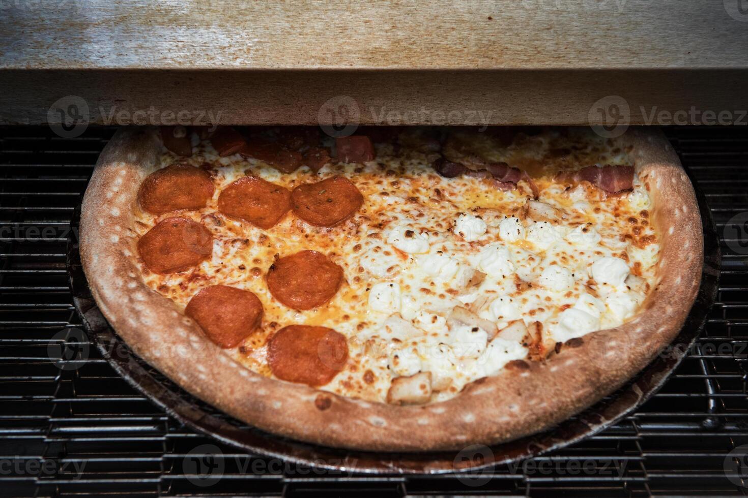 Preparing pizza in oven photo