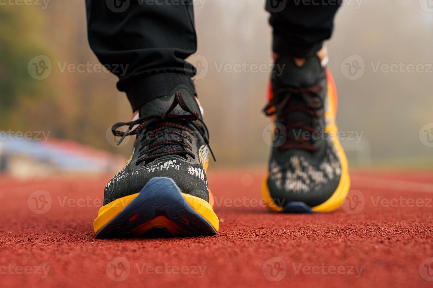 Runner wearing modern sport shoes standing on track surface photo