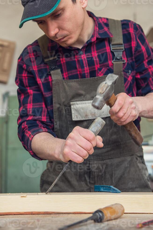 Carpenter working with a chisel photo