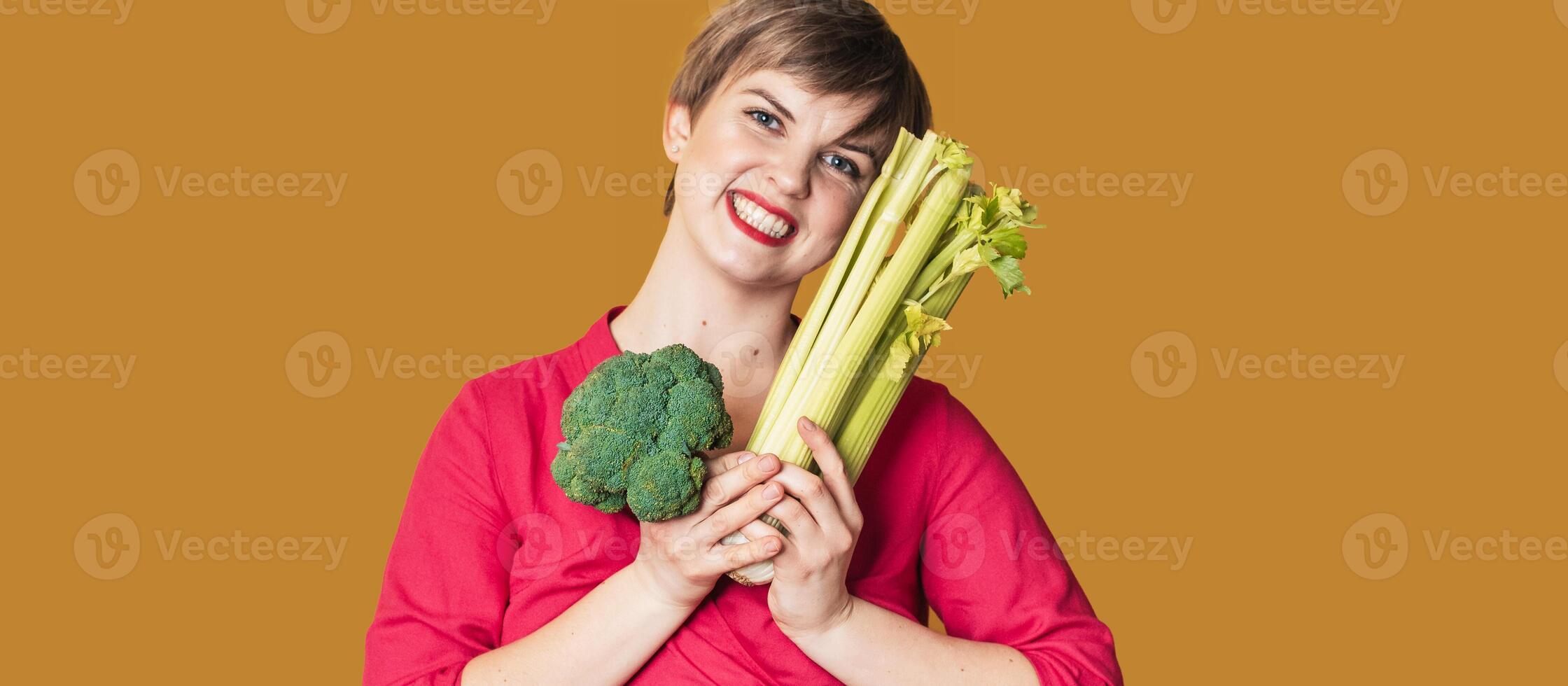 Smiling slender Caucasian girl with green vegetables in her hands, free space. Organic vegetables. photo