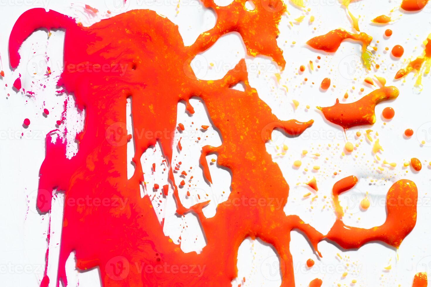 Orange pink paint drops and splotch on white background photo