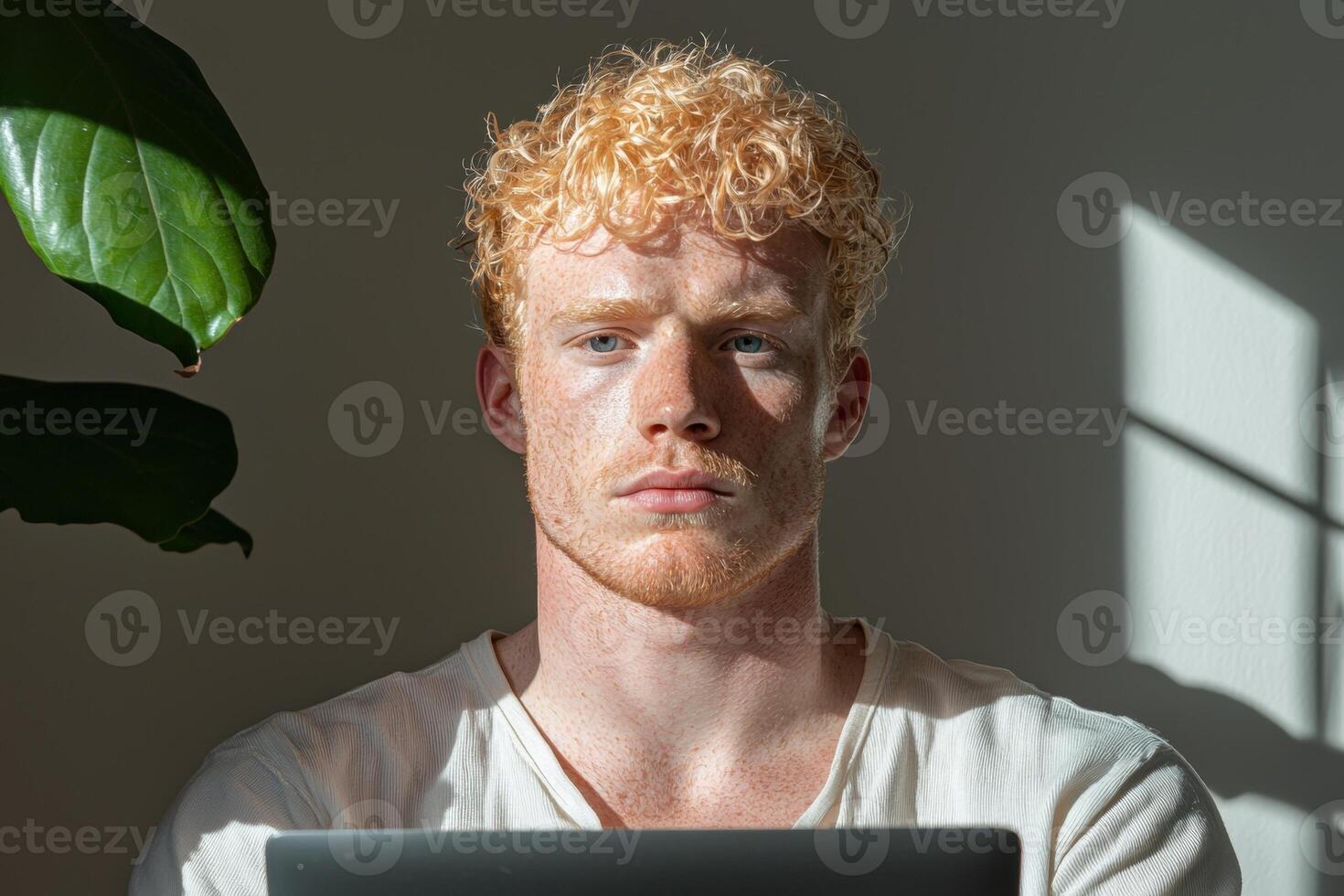 Young redhead man with freckles working from home on laptop photo