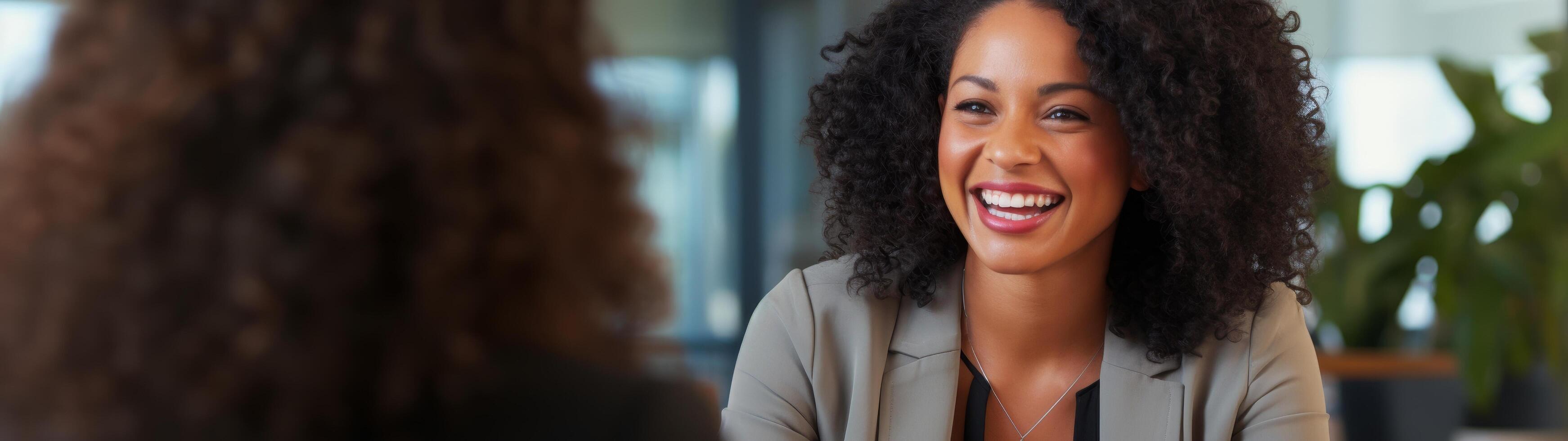 smiling woman with curly hair in a professional setting photo