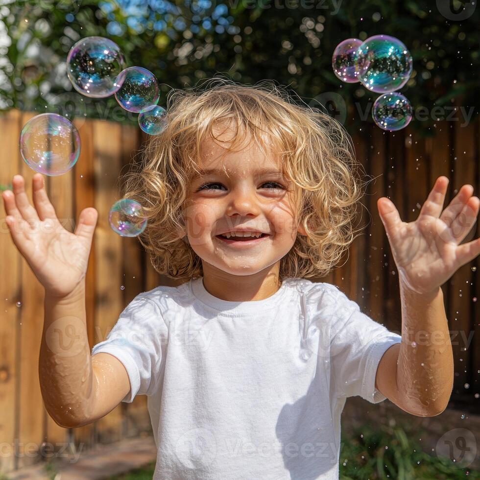 Happy toddler playing with bubbles outdoors on a sunny day photo