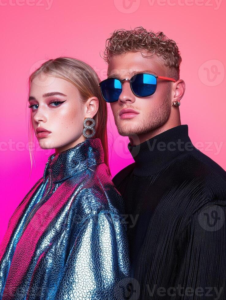 Stylish couple posing together in trendy sunglasses against a vibrant pink background photo