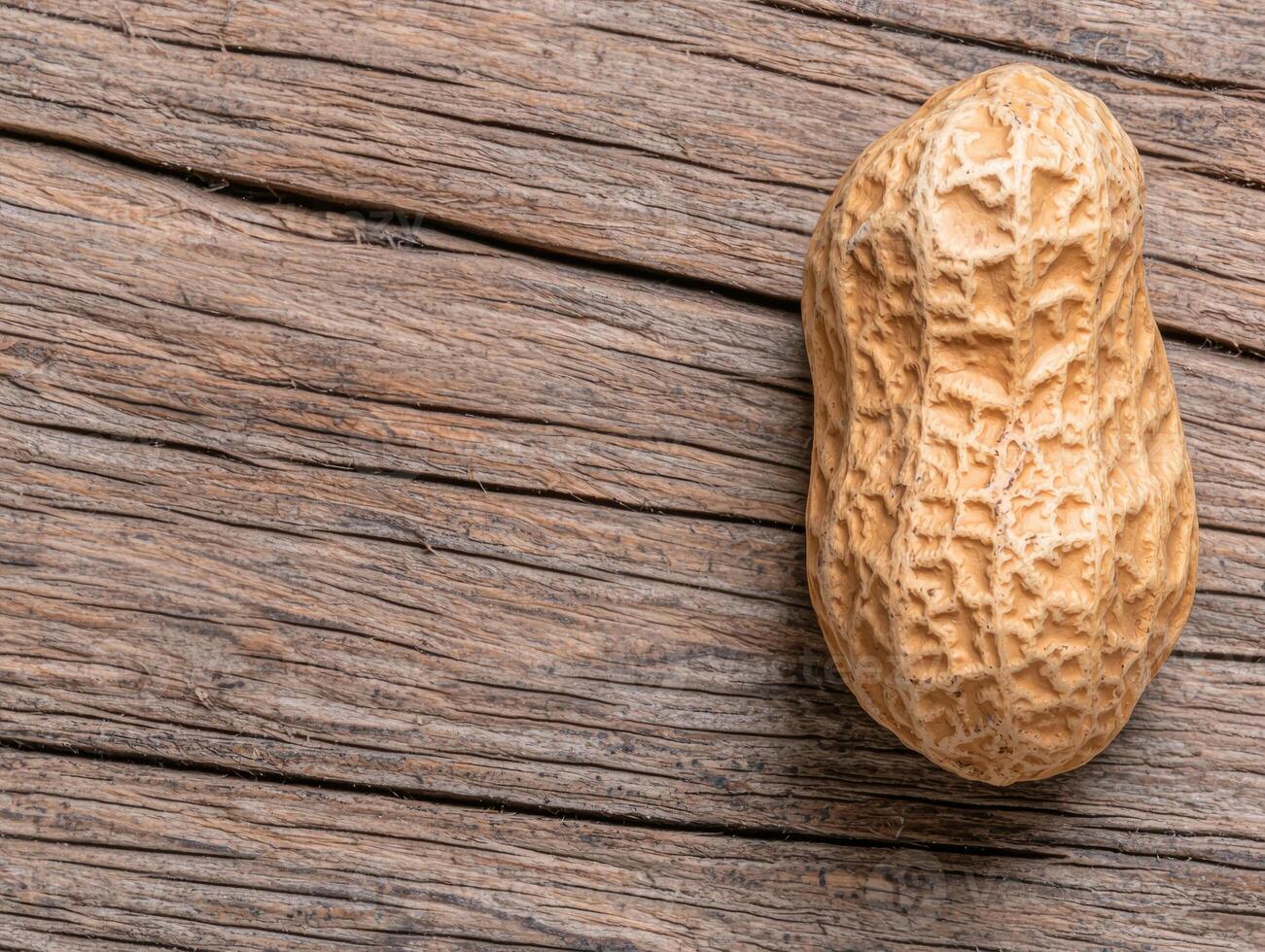 Single peanut in shell on rustic wooden background photo