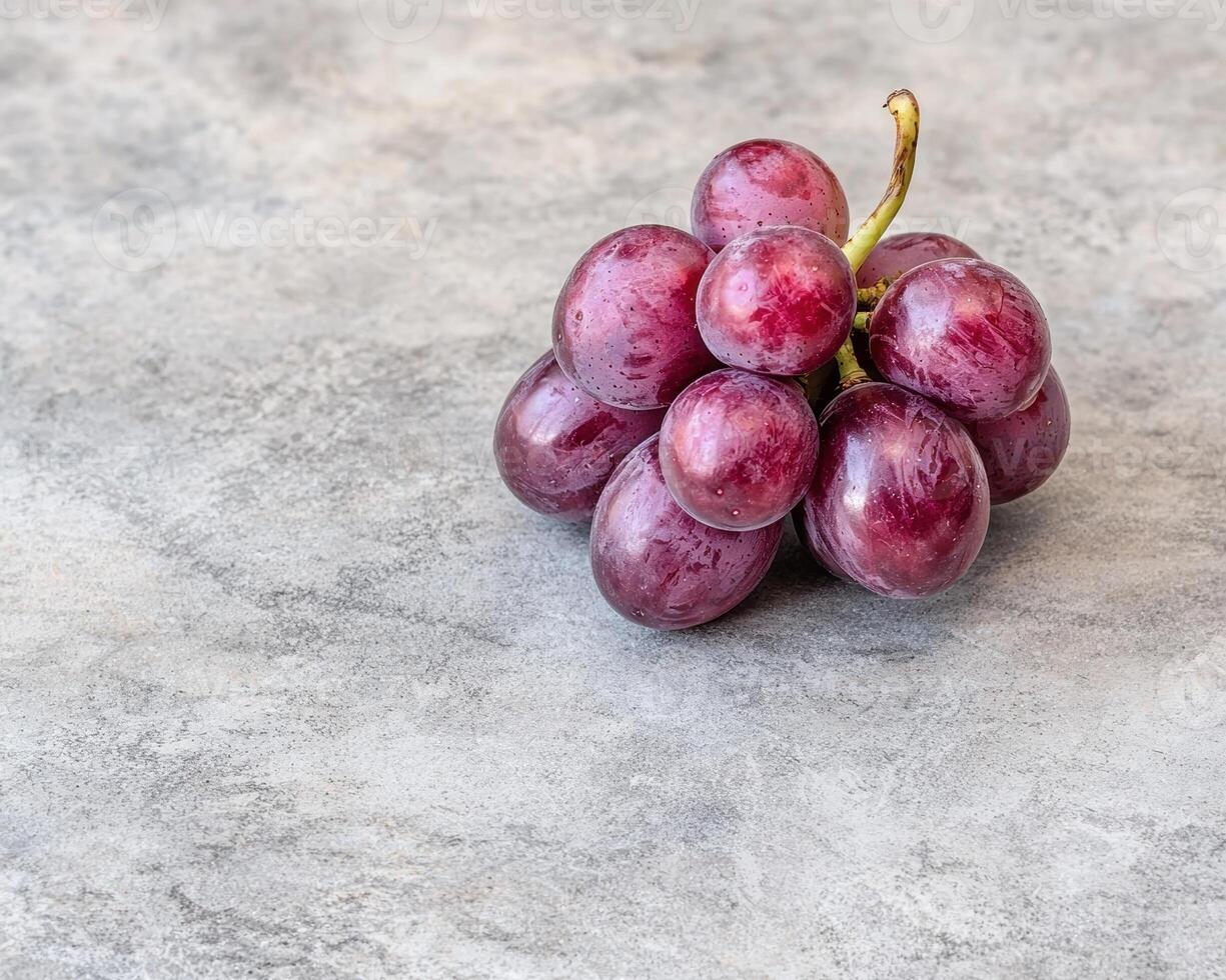 Close up of a bunch of red grapes on a gray background photo