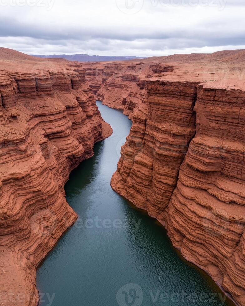 Aerial view of a stunning red rock canyon with a deep blue river flowing through it photo