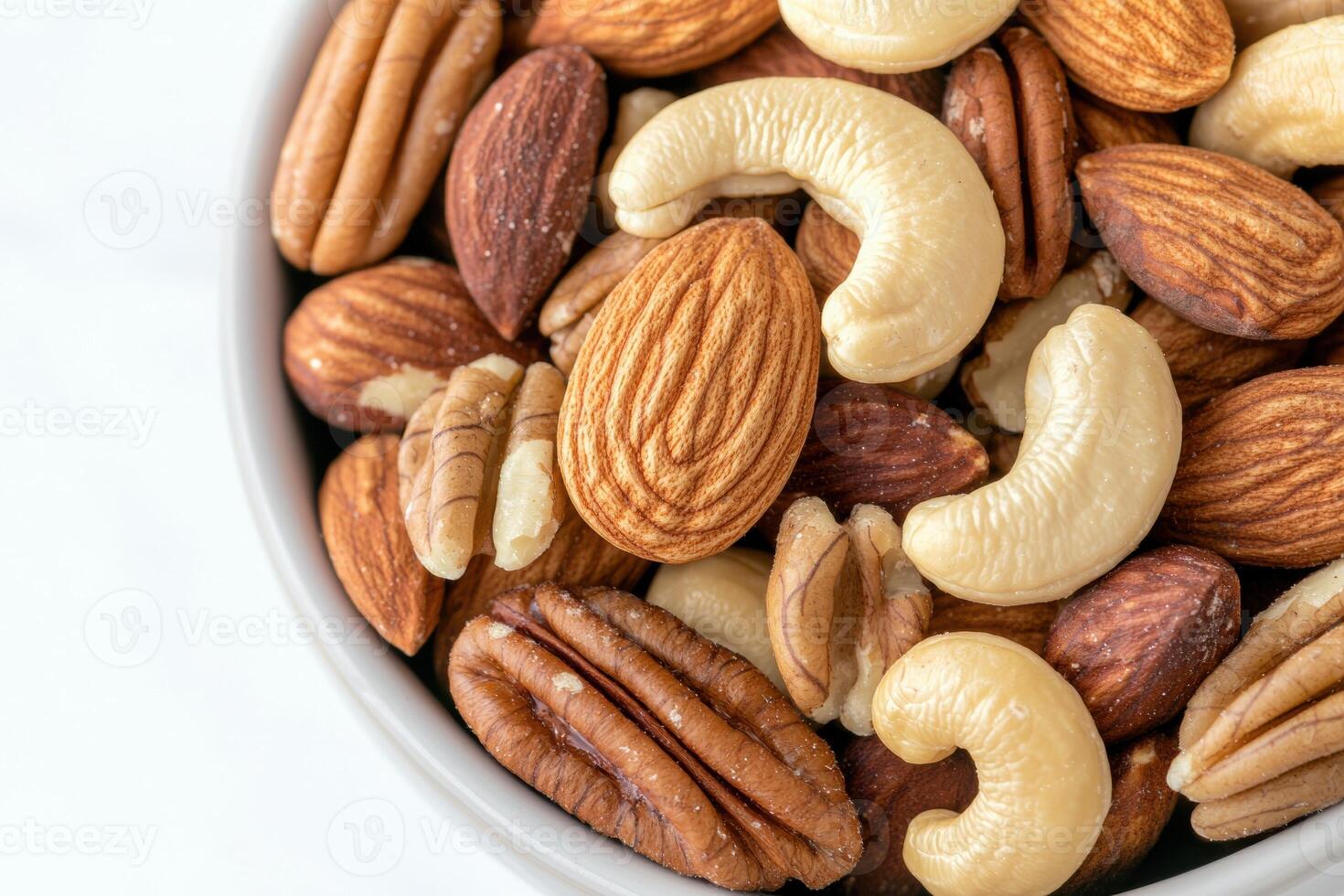 Close up of a bowl of mixed nuts, including almonds, cashews, and pecans photo
