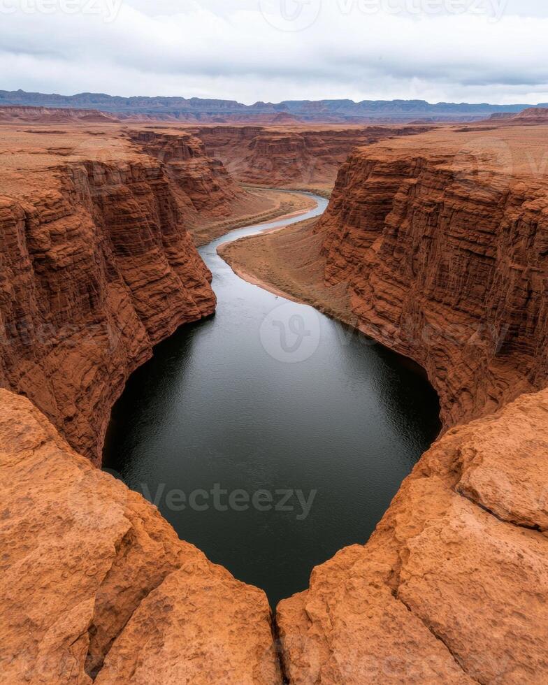 Aerial view of a winding river cutting through a deep canyon in a desert landscape photo