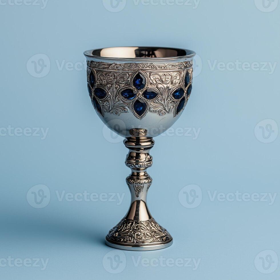 Ornate silver goblet with blue gems on a light blue background photo