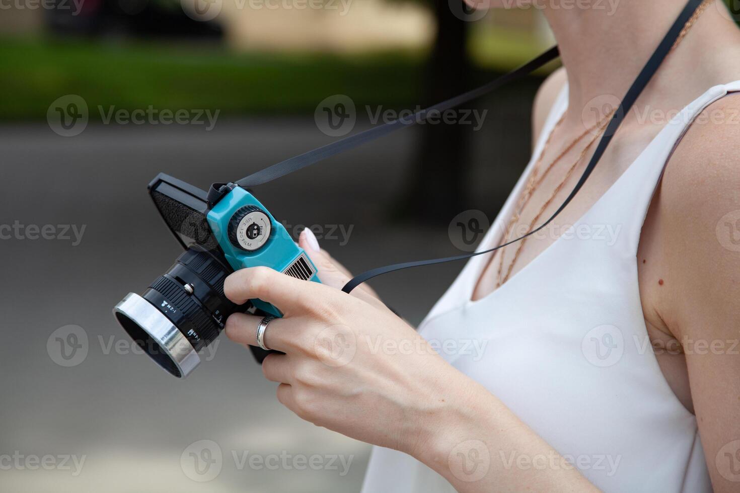 A girl is holding a digital camera in her hands photo