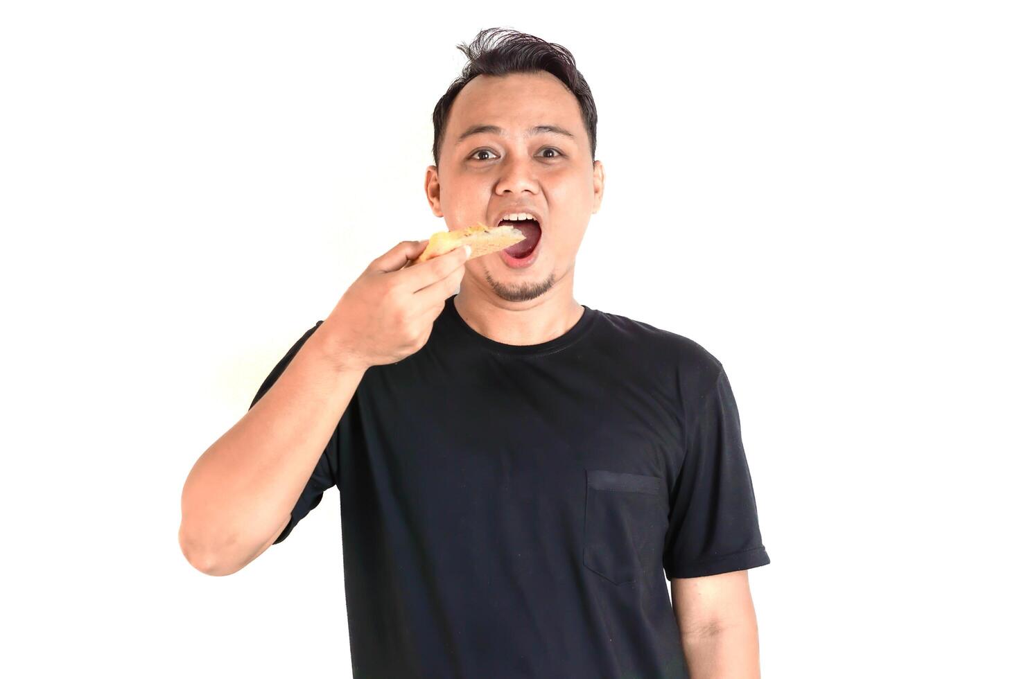 Enjoying a Delicious Slice of Pizza in a Black T-Shirt photo