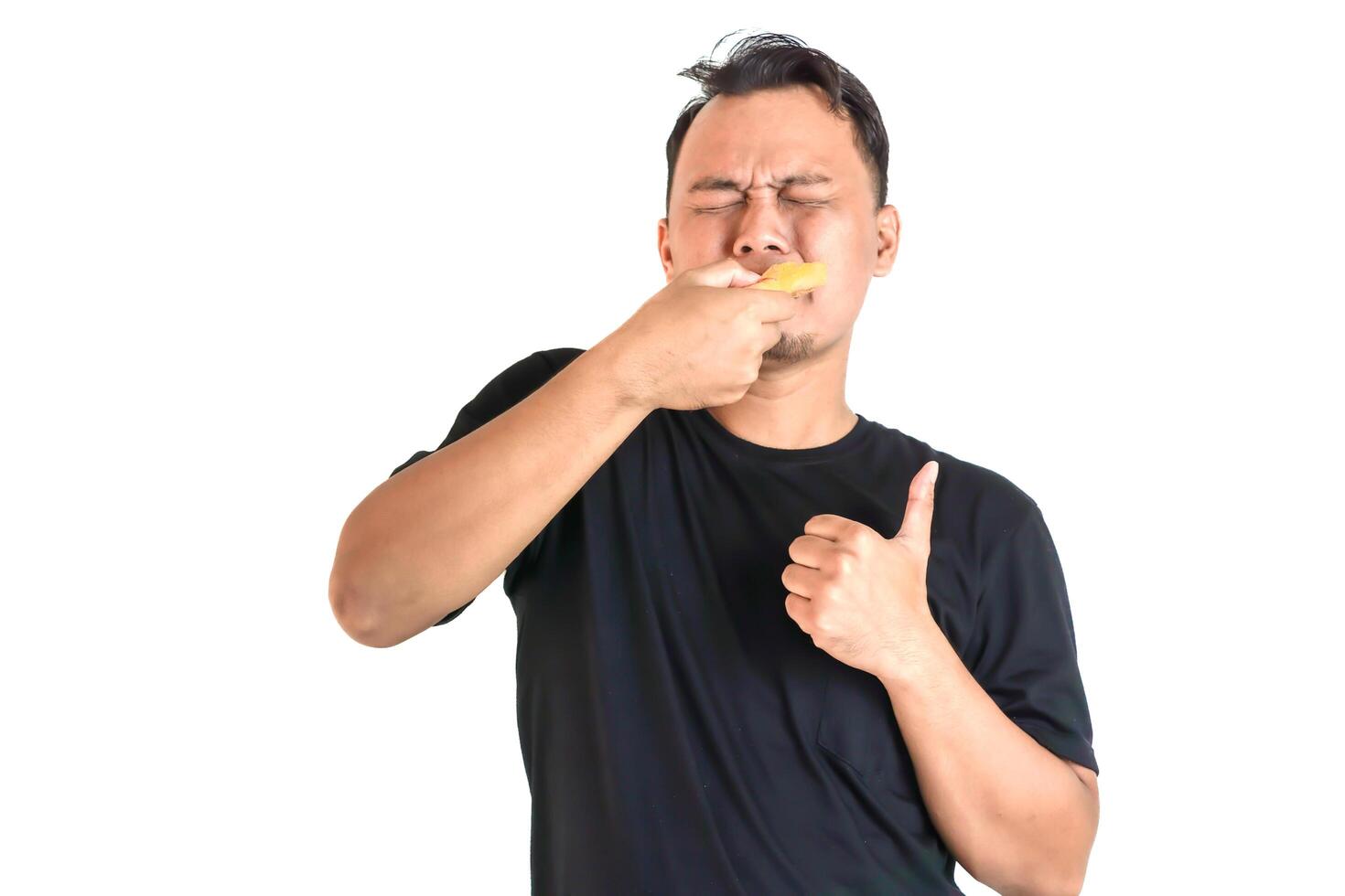 Man Enjoying a Delicious Snack with a Thumbs Up photo