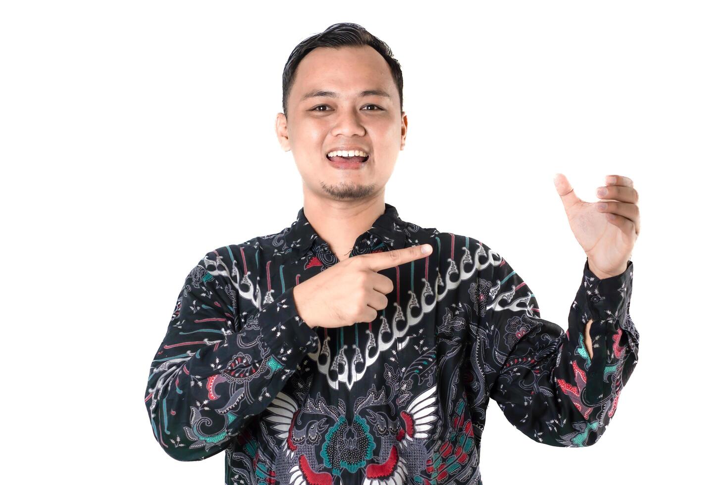 Man in Batik Shirt Cheerfully Gesturing Towards Something Invisible photo