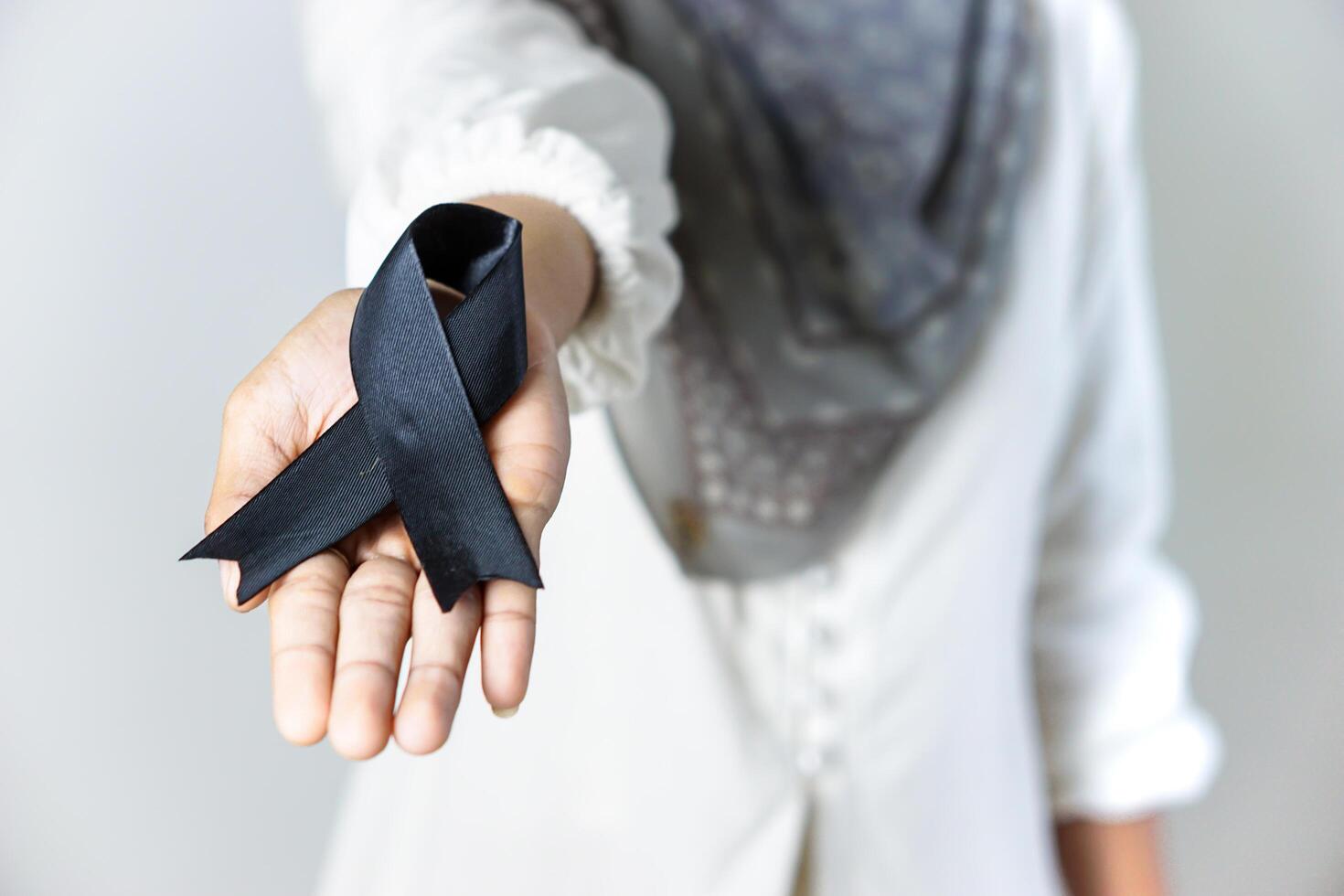 Woman Holding Black Ribbon Symbolizing Awareness or Mourning photo