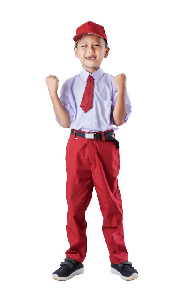 A cheerful Indonesian boy in a red and white uniform, raising his fists in excitement and confidence. photo