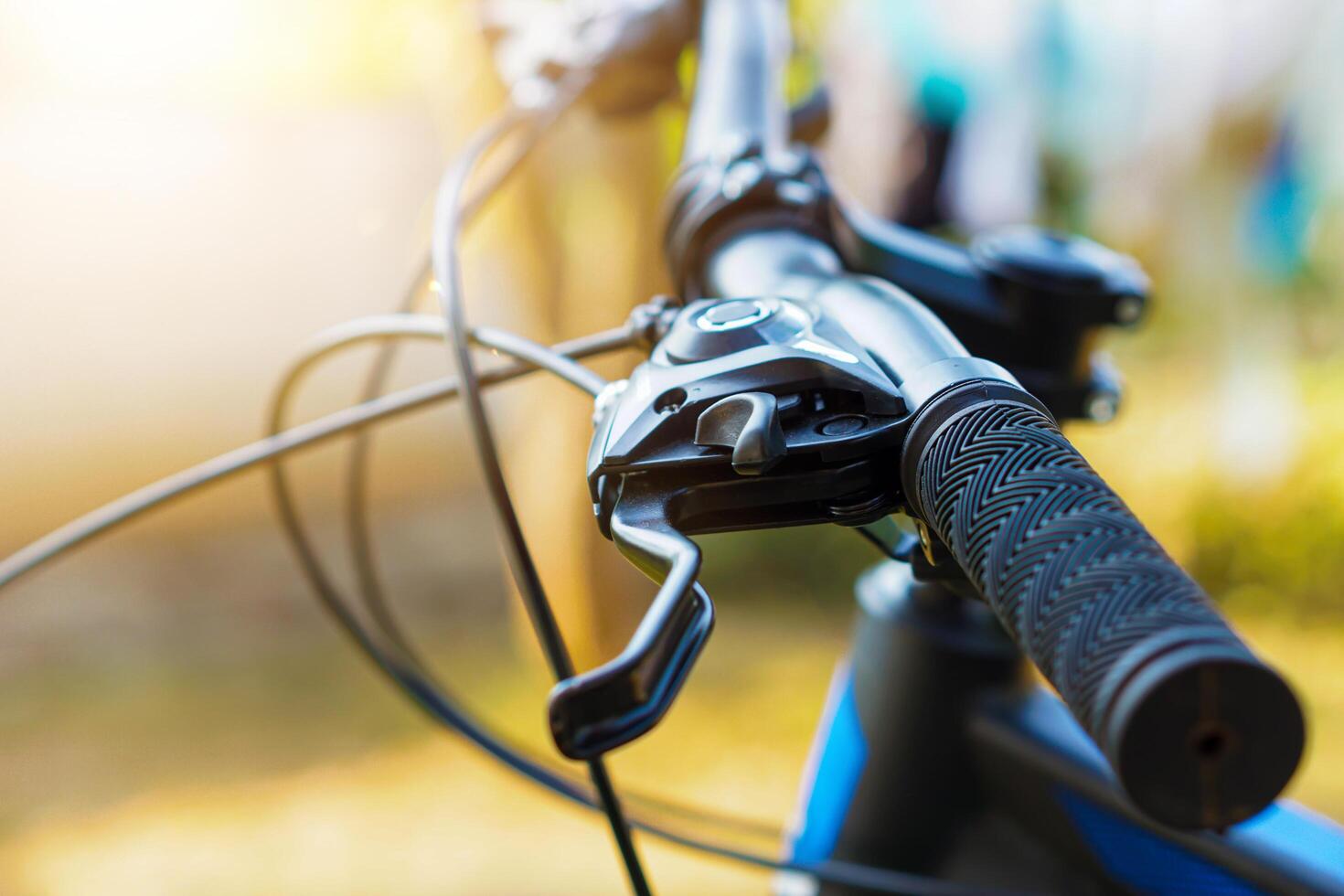 selective focus Close-up view of a bicycle handlebar and brake lever, showcasing the textured grip and cable details. photo