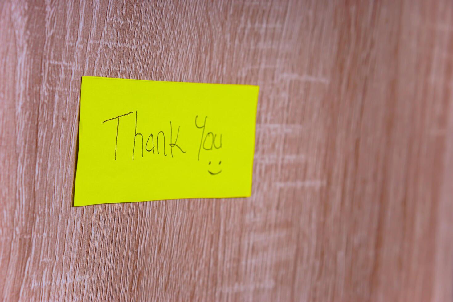 A cheerful note saying Thank You on a bright yellow sticky note, enhancing positivity in any space. photo