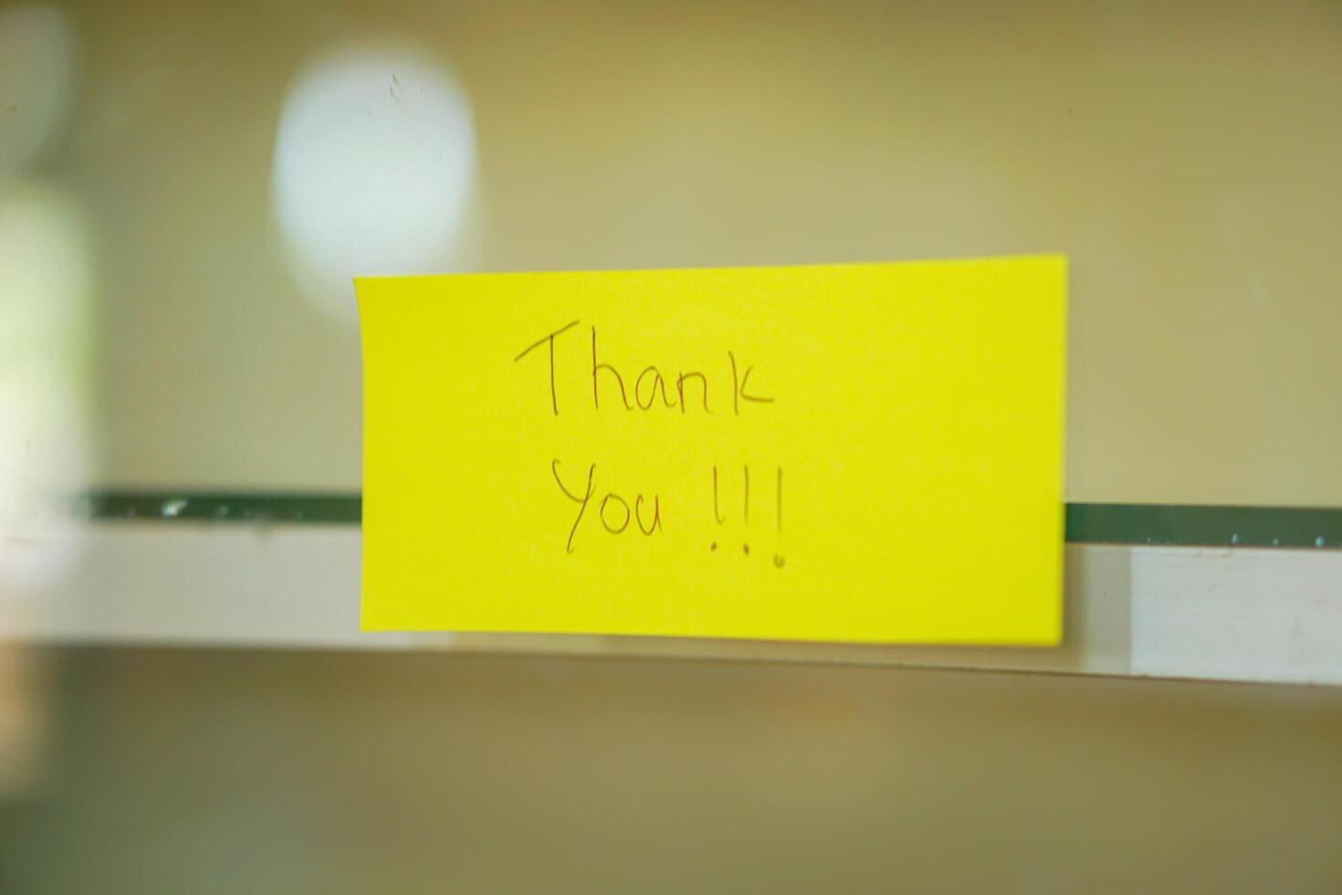A cheerful note saying Thank You on a bright yellow sticky note, enhancing positivity in any space. photo