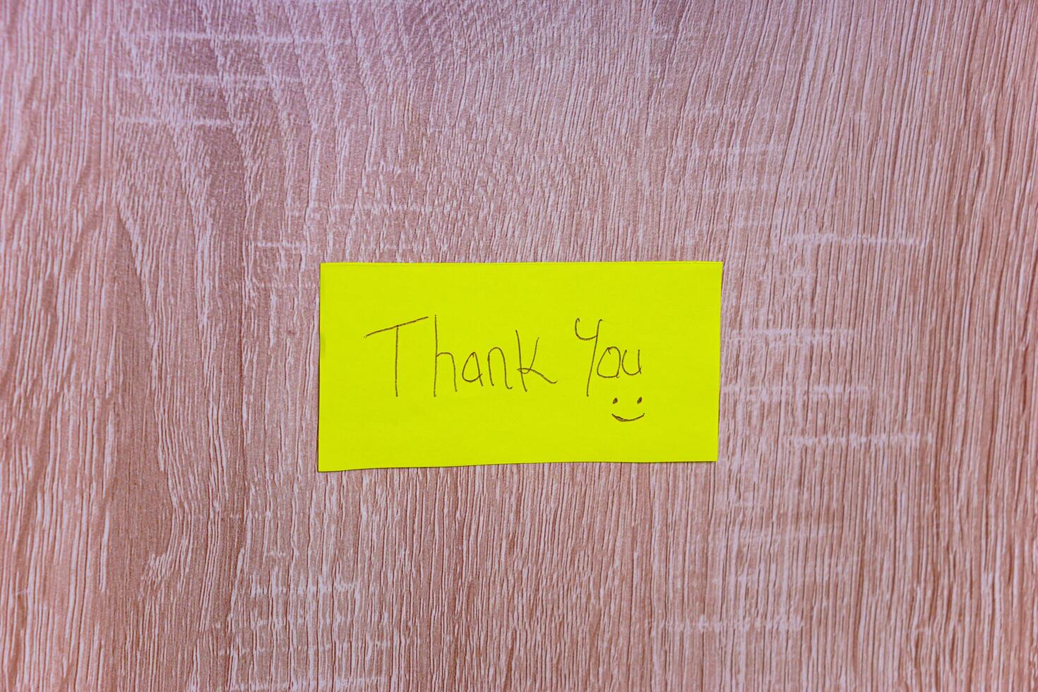 A cheerful note saying Thank You on a bright yellow sticky note, enhancing positivity in any space. photo