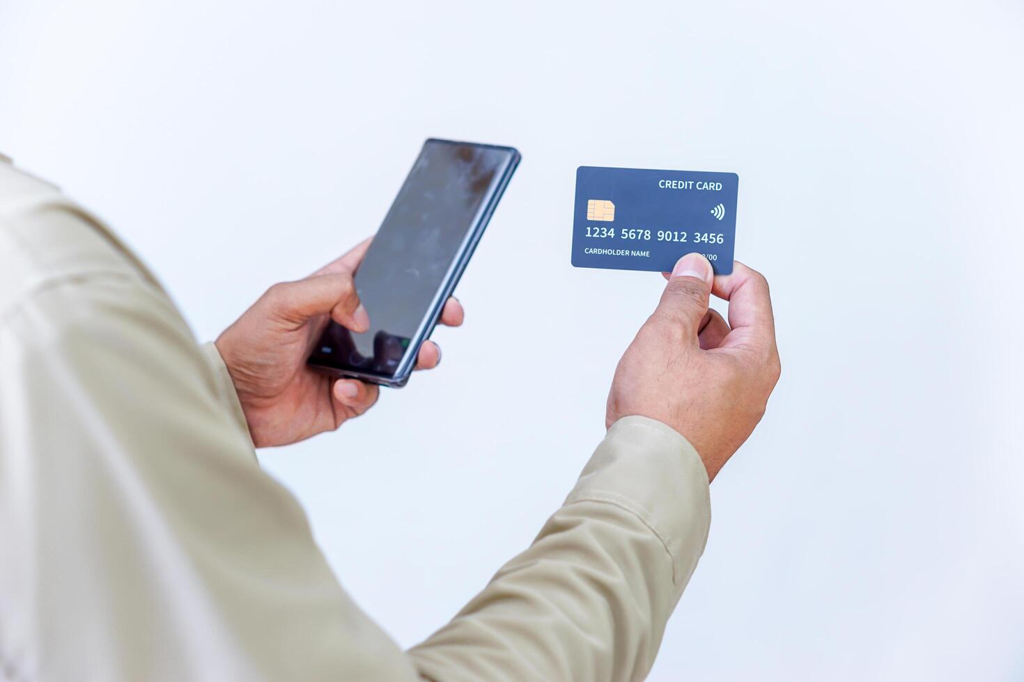 A person holding credit cards and a phone, ready for a transaction or payment. photo