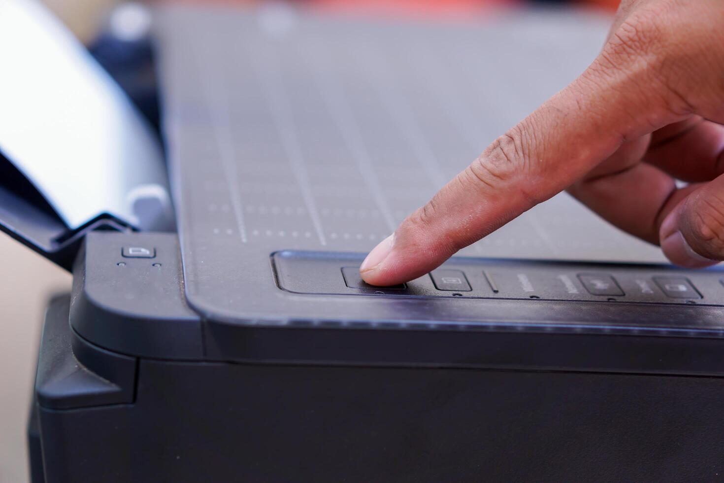 Finger pressing the printer power button photo