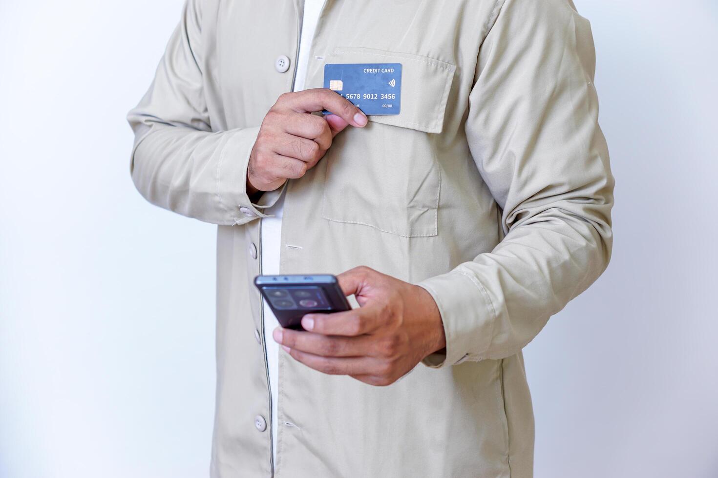 A person holding credit cards and a phone, ready for a transaction or payment. photo
