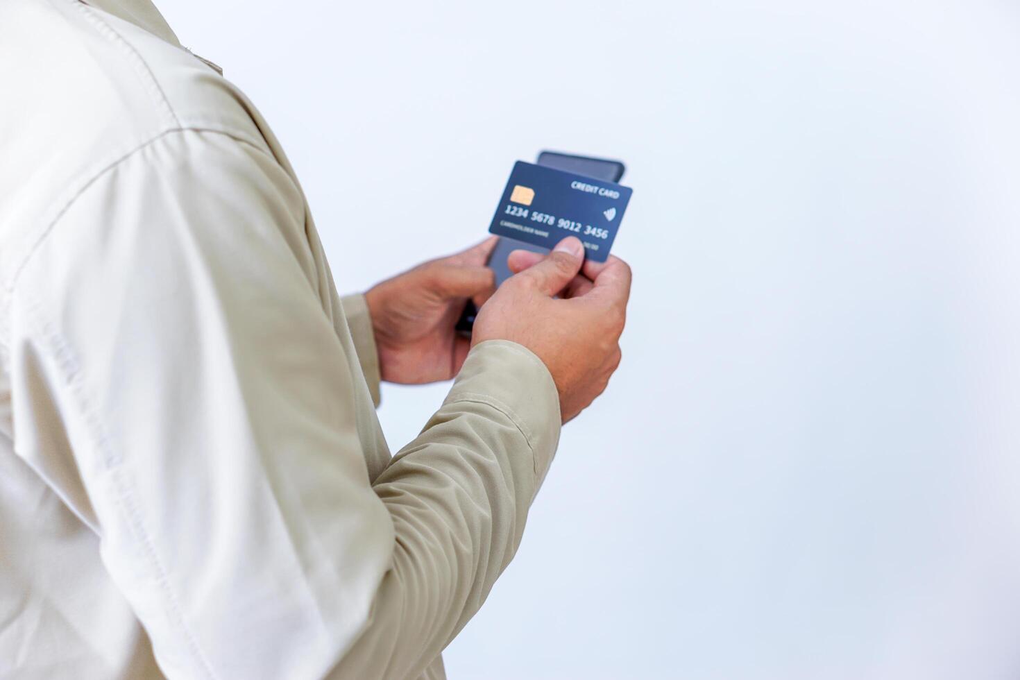A person holding credit cards and a phone, ready for a transaction or payment. photo