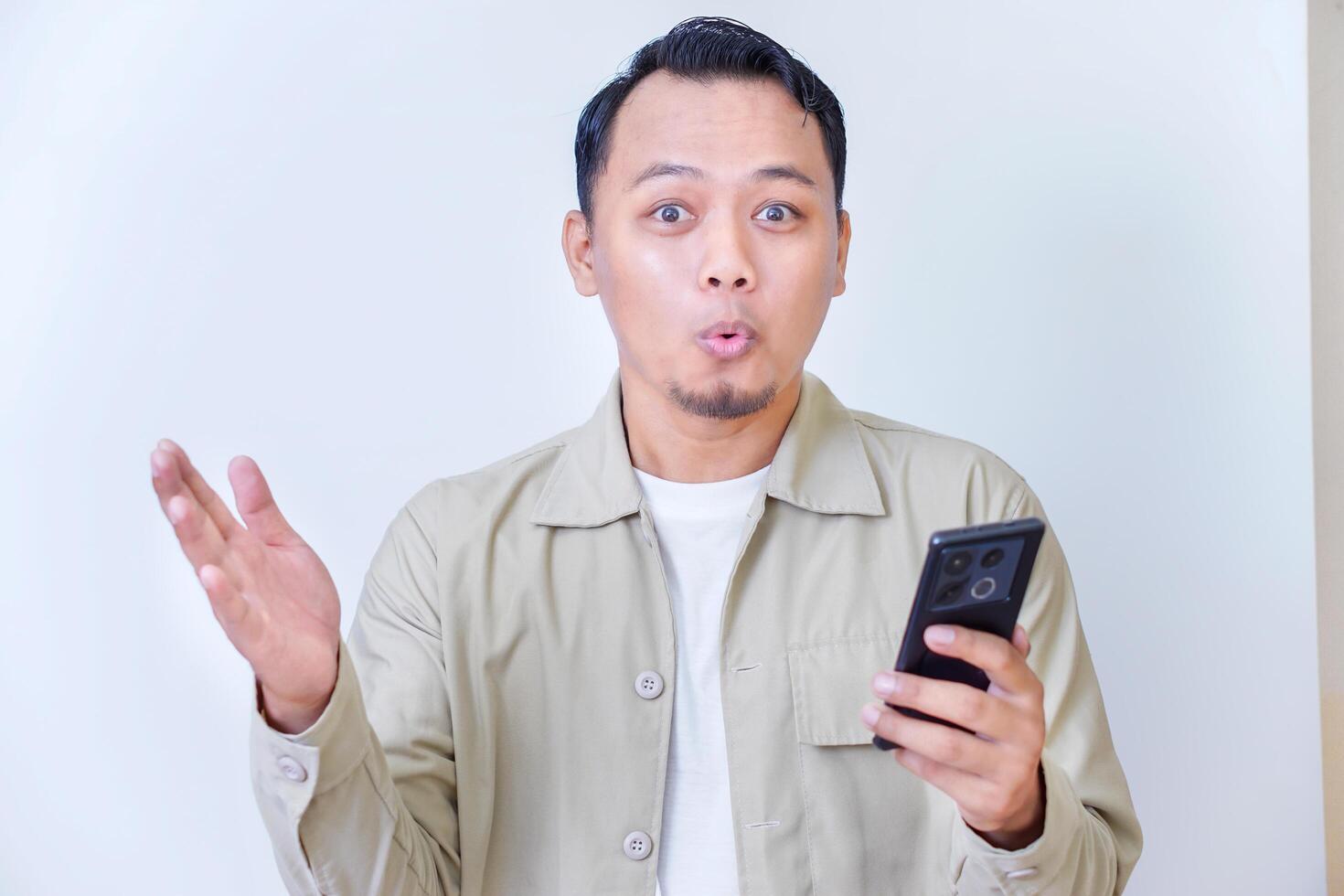 A man joyfully reacts to something exciting on his smartphone. photo