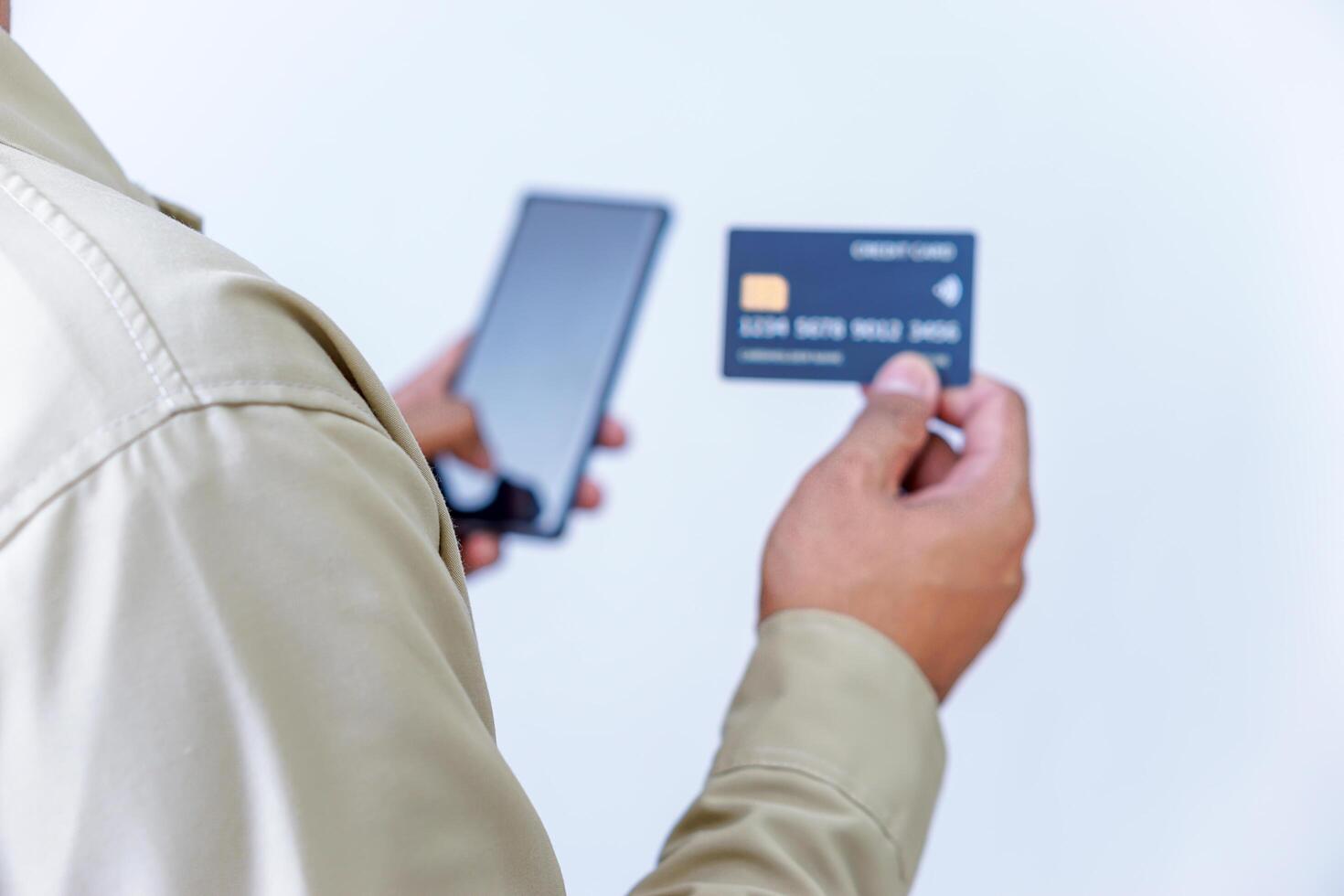 A person holding credit cards and a phone, ready for a transaction or payment. photo