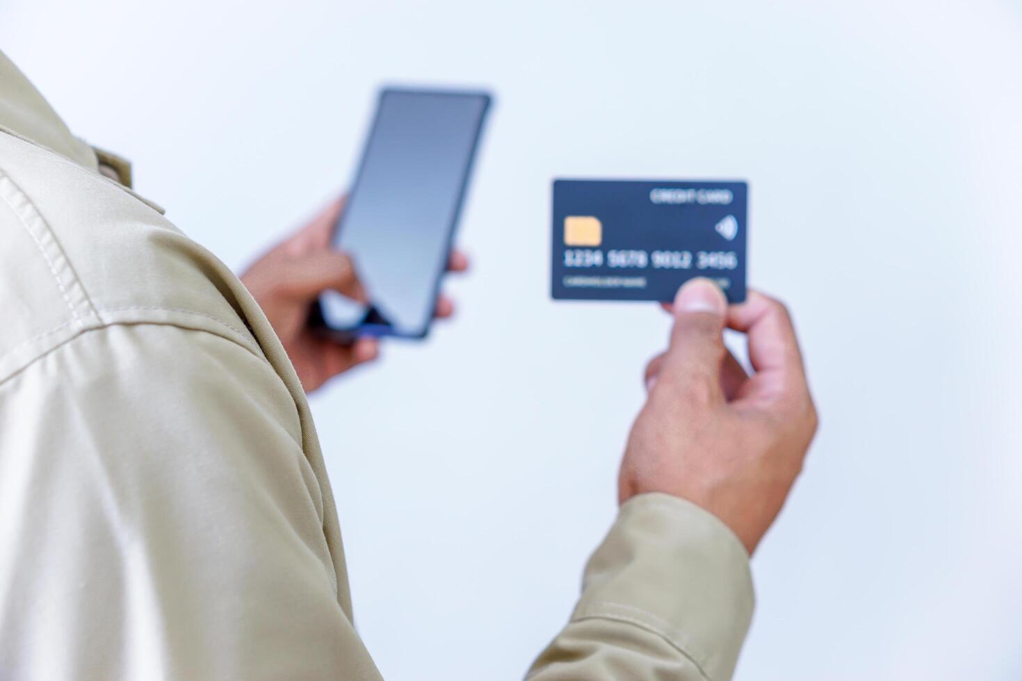 A person holding credit cards and a phone, ready for a transaction or payment. photo
