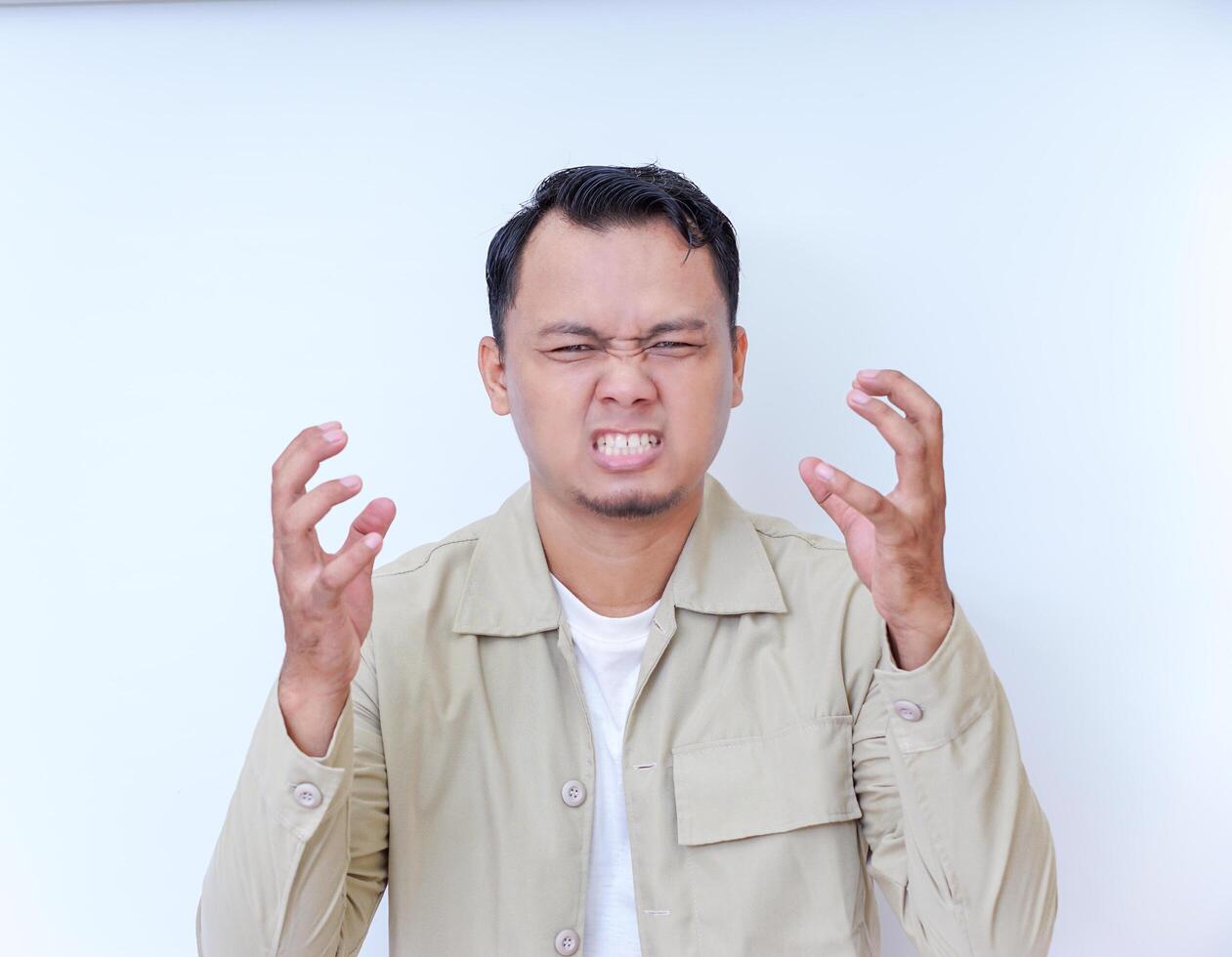 A man expresses frustration with his hands on his head and a shout. photo