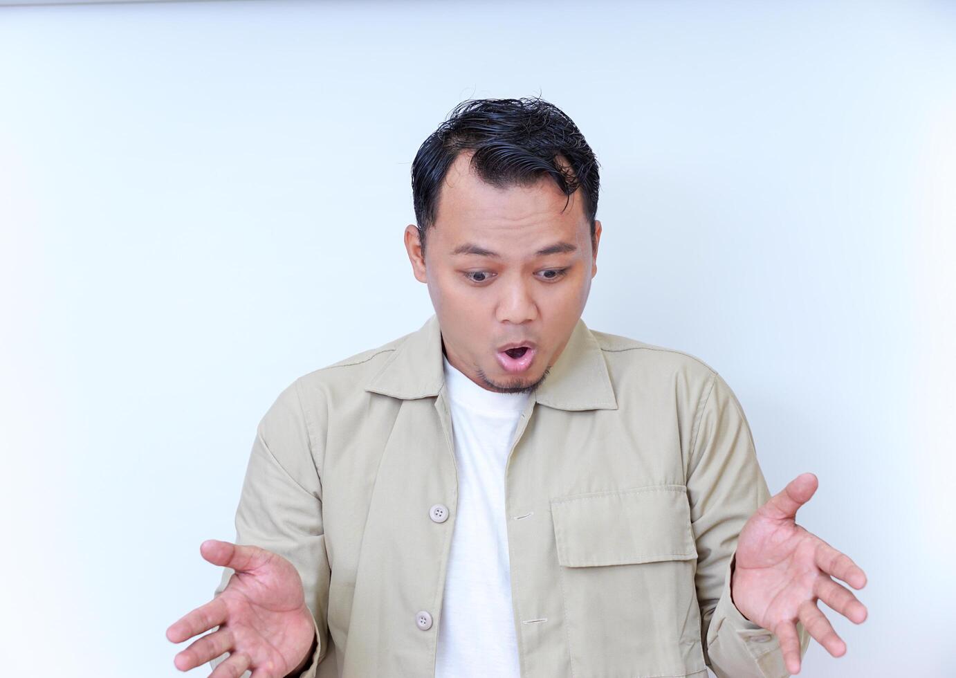 A surprised man reacts with astonishment, expressing his disbelief. photo