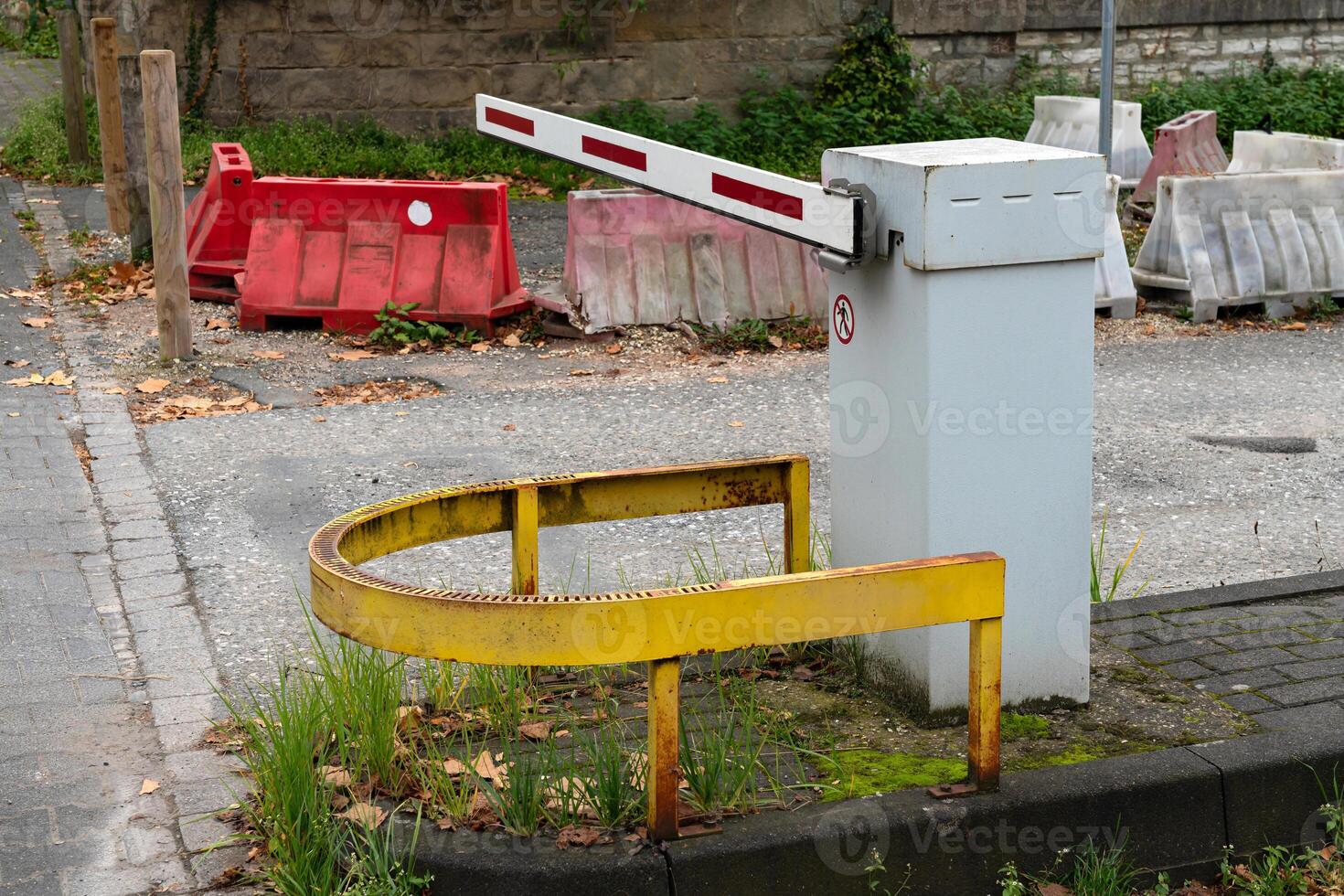 Barrier in the parking lot with a yellow metal fence closed in a photo