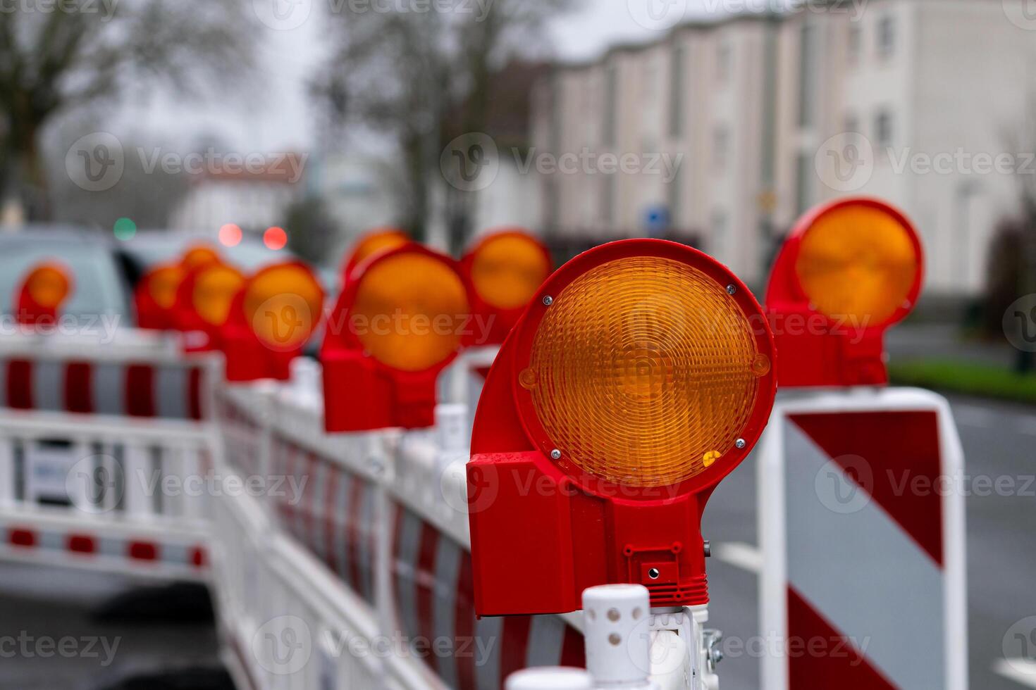 Construction barriers with warning lights in urban setting at dusk photo
